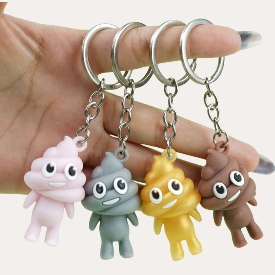 Four poop key chains being held on the fingers of a person