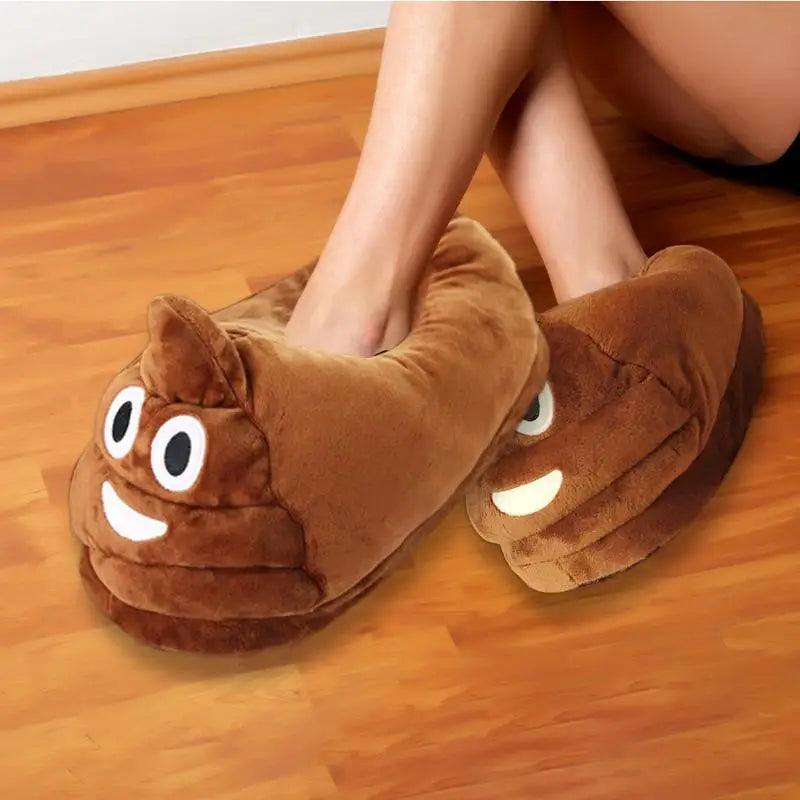 Person wearing brown poop emoji slippers with smiling faces on a wooden floor.