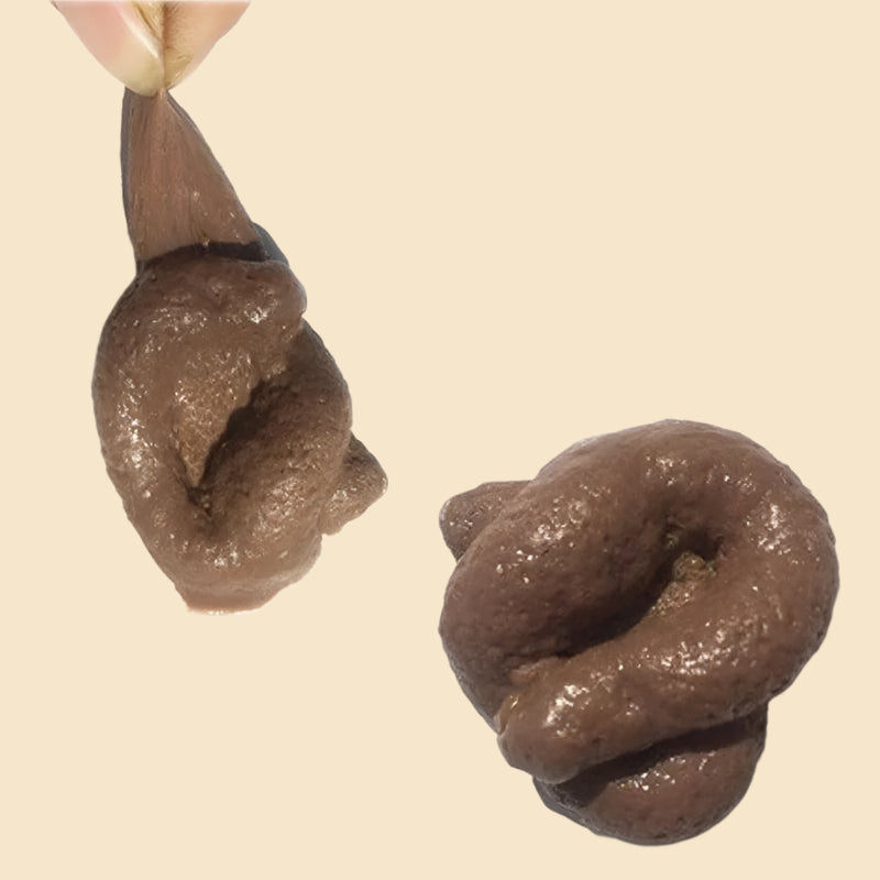 Realistic fake poop shaped like a coil, placed on a white background with a hand lifting it.