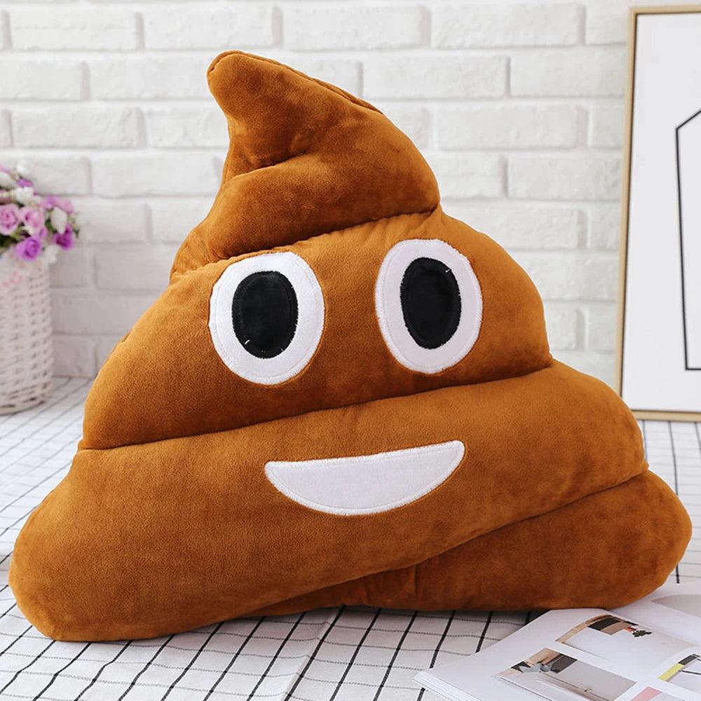Plush smiling poop pillow, brown and happy, on a checkered cloth with flowers.