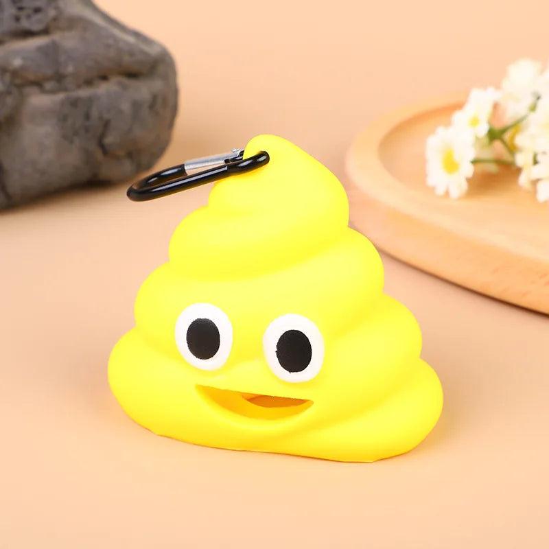 Yellow poop emoji poop bag dispenser with a carabiner clip, smiling with big eyes on a beige background with flowers.